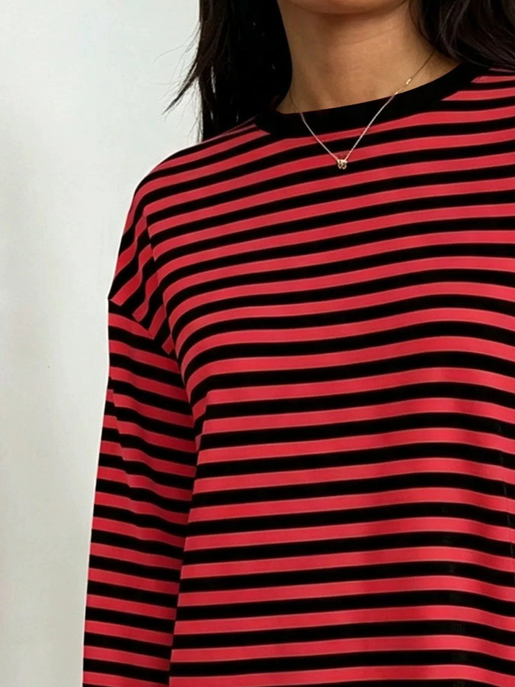 Zoomed view of red and black striped shirt shoulder area displaying contrast between vibrant red and deep black bands