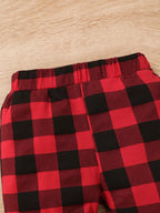 Cintura elástica de los pantalones a cuadros rojo y negro mostrando construcción recogida y patrón de poliéster elastano a cuadros