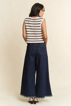 Back view of openwork striped vest and high-waisted wide-leg jeans with visible back pockets and raw edge hems
