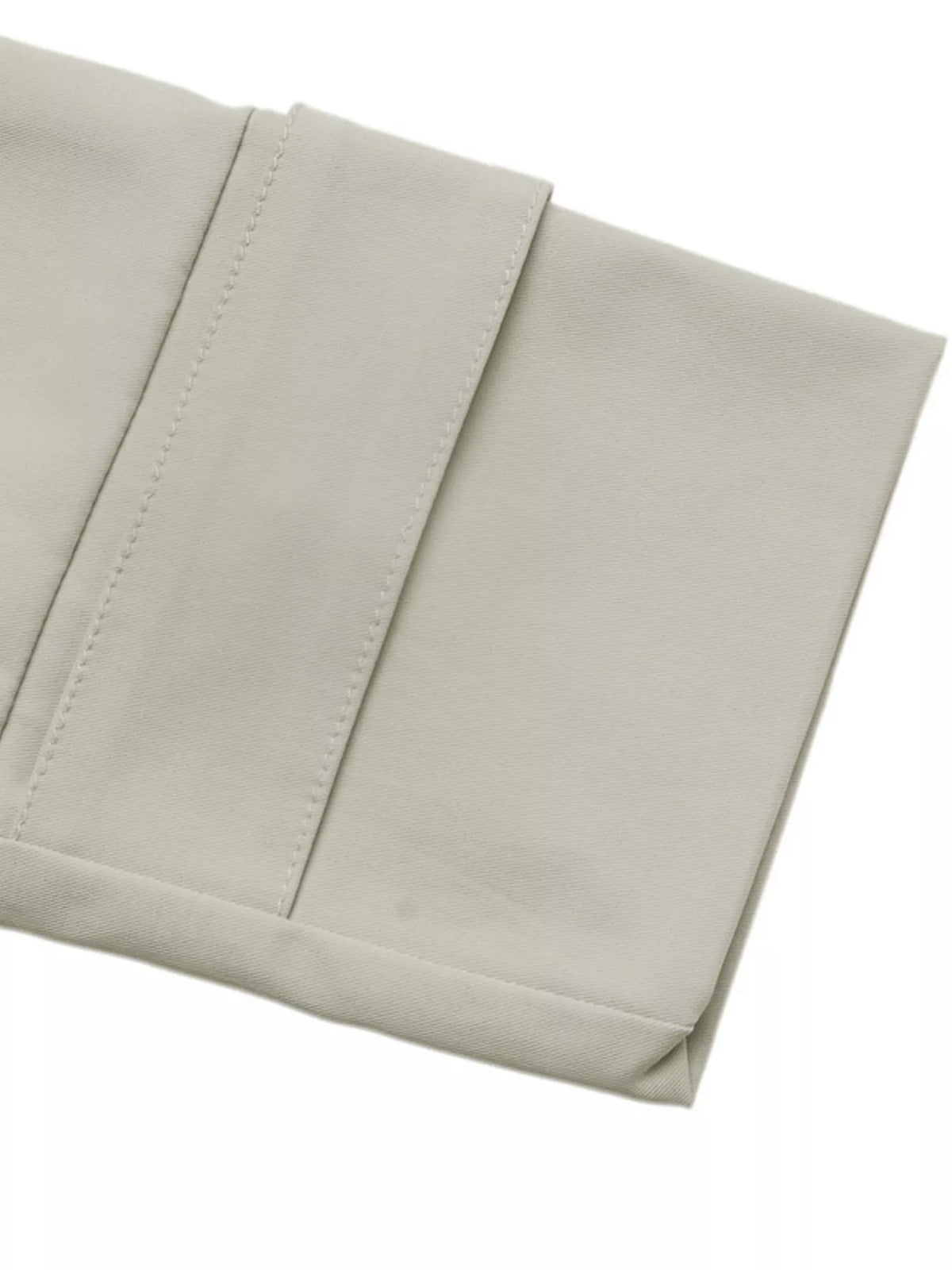 Macro du poignet de manche double-couture sur texture de tissu lisse beige clair
