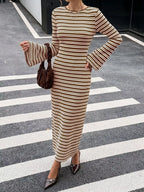 Modell in braun-weiß gestreiftem, geripptem Strick-Midi-Kleid mit Flare-Ärmeln und Samthandtasse auf dem Zebrastreifen