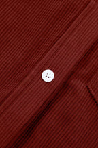 Extreme close-up of single white plastic button on brown corduroy placket weave
