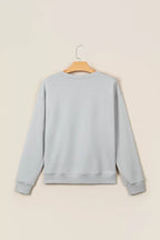 Back view of light grey long-sleeve sweatshirt on wooden hanger. Plain design features ribbed cuffs and hem against neutral
