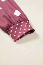 Sleeve cuff detail showing transition from large to small white polka dots on gathered elasticated hem