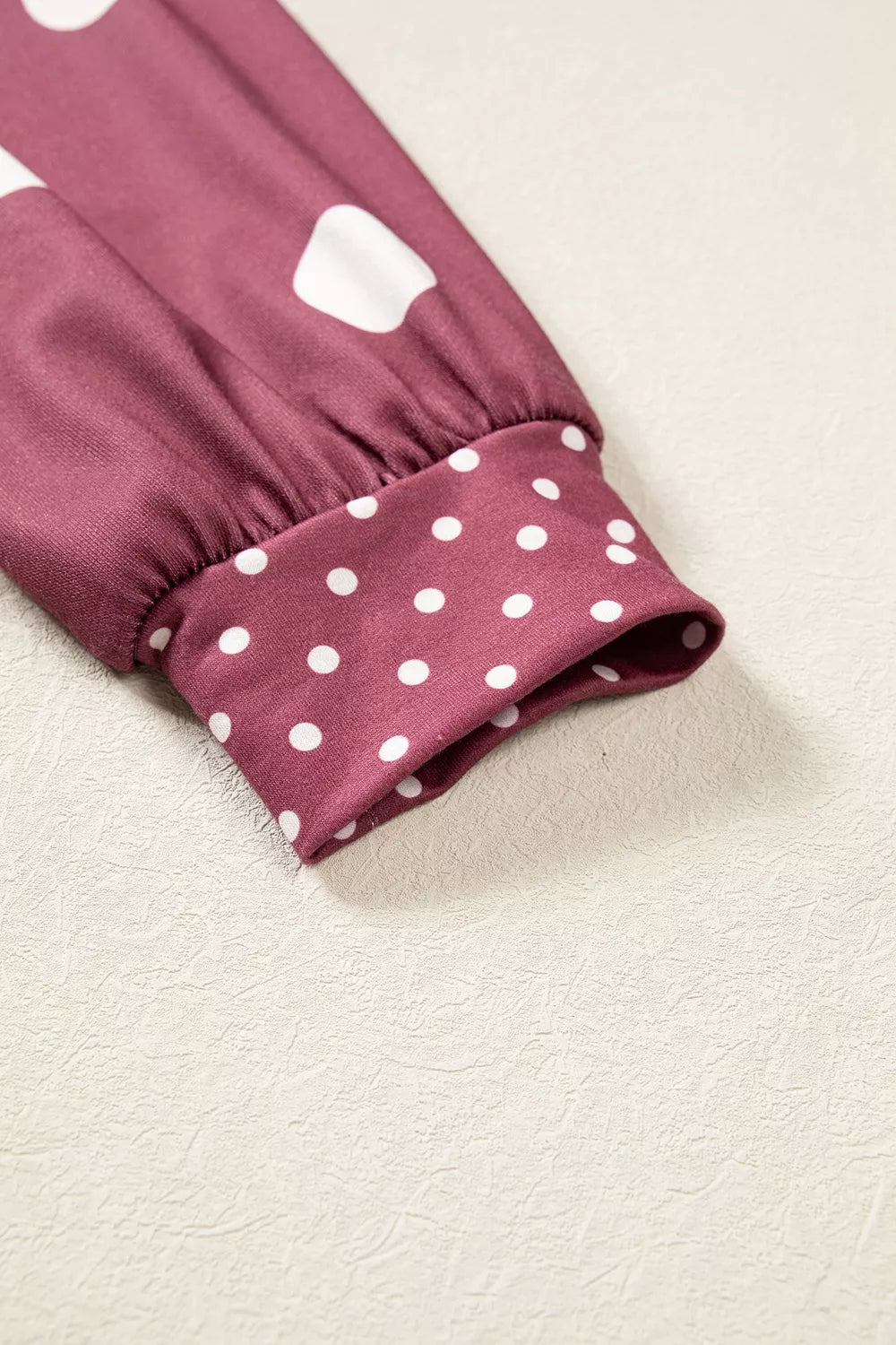 Sleeve cuff detail showing transition from large to small white polka dots on gathered elasticated hem