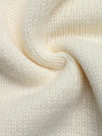 Makroaufnahme der weichen, feinmaschigen Textur und der gedrehten Garne der cremefarbenen Strickware