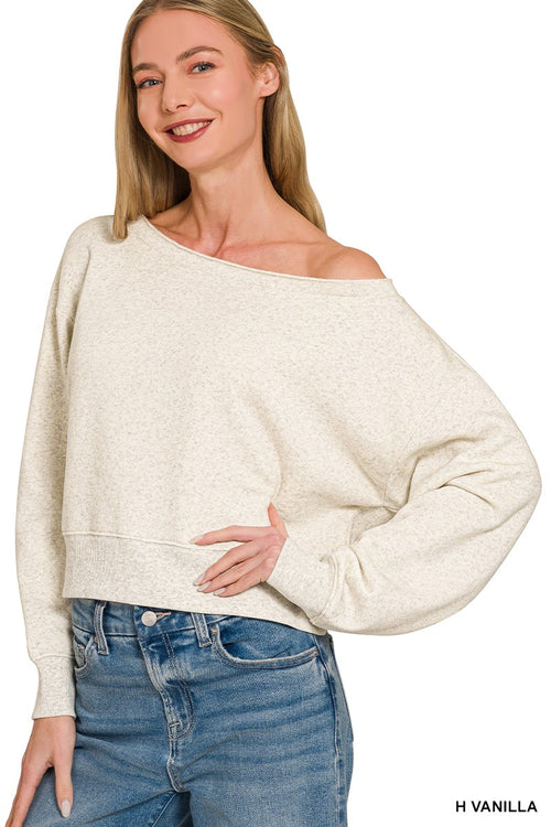 Off-white speckled fleece pullover draped loosely on model posing with hand on hip