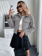 Blonde Frau im Spiegel-Selfie trägt hellgraue Perfee Zip-Up Cropped Shacket mit Klappentaschen über weißem Top und schwarzem Rock