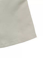 Détail de l'ourlet inférieur montrant une couture droite nette sur le matériau de veste beige uni