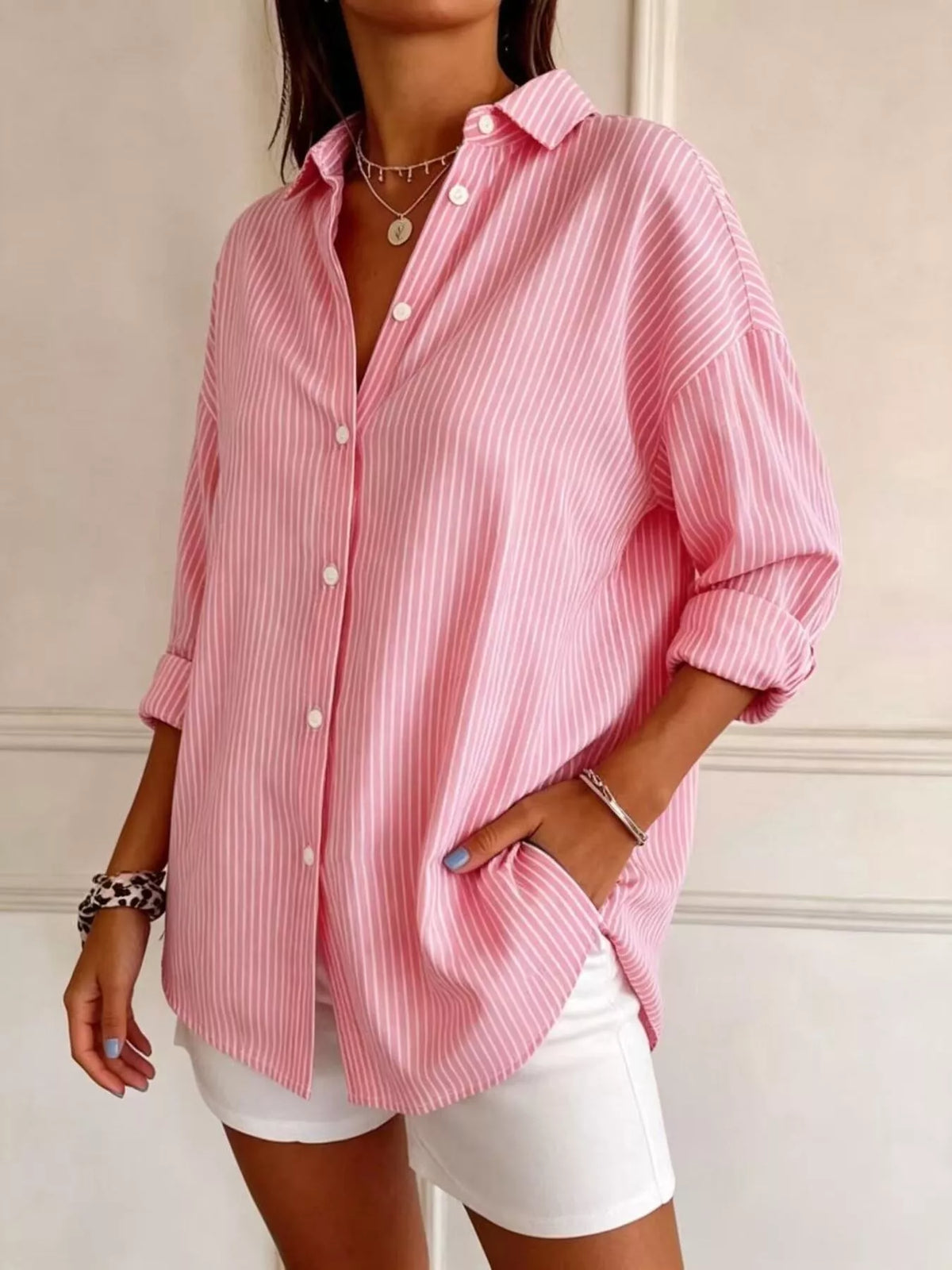 Pinke Bluse mit weißen Streifen, entspannte Passform, aufgerollte Ärmel, Seitentaschen, weiße Shorts