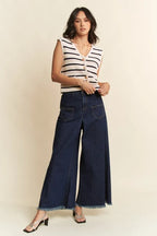 Full body outfit featuring striped vest tucked into high-waisted frayed denim jeans with silver strappy sandals