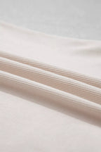 Extreme close-up of fine vertical ribbed texture on soft matte beige fabric