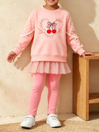 Mädchen in rosa Sweatshirt mit Kirschmotiv und Tulle-Leggings mit weißen Sternärmeln