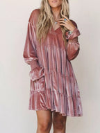Inquadratura media di un vestito in velluto frangiato color marrone-rosa che evidenzia polsini elastici e texture del tessuto