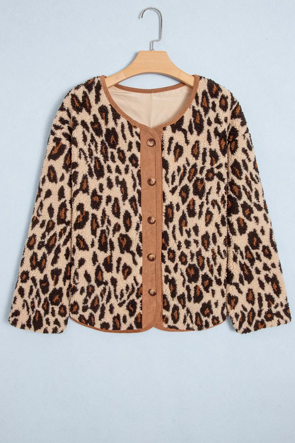 Leopard print jacket on wooden hanger featuring round neckline with brown corduroy trim and five buttons