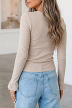 Back view of fitted beige ribbed top showing vertical texture and lace cuffs