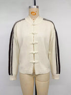 Frontalansicht der elfenbeinfarbenen Jacke am Mannequin mit Stehkragen und traditionellen Knopfverschlüssen