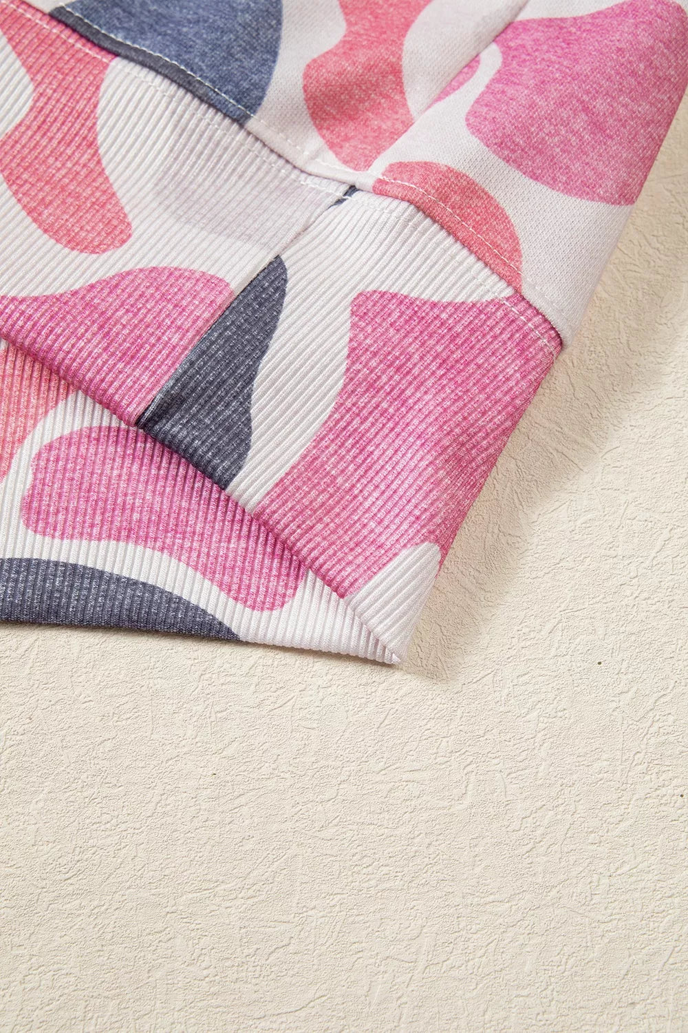 Vertical ribbing of elasticated hemline seamlessly integrated with colorful abstract pattern