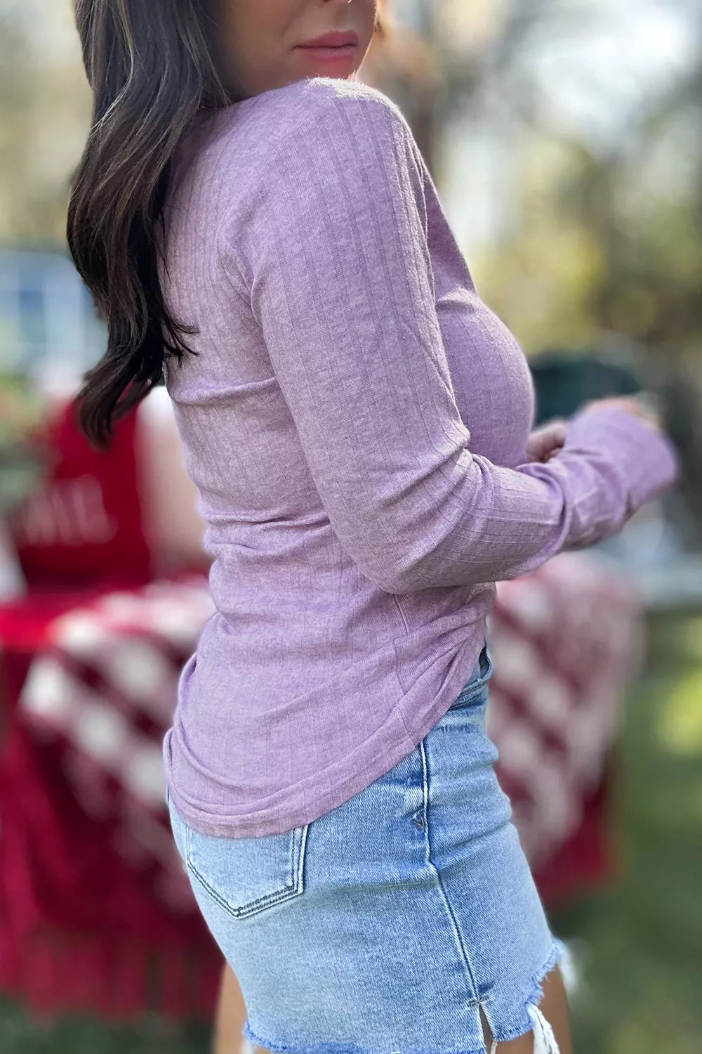 Side-back view of lavender ribbed top demonstrating drape, flexibility, and gathered sleeves