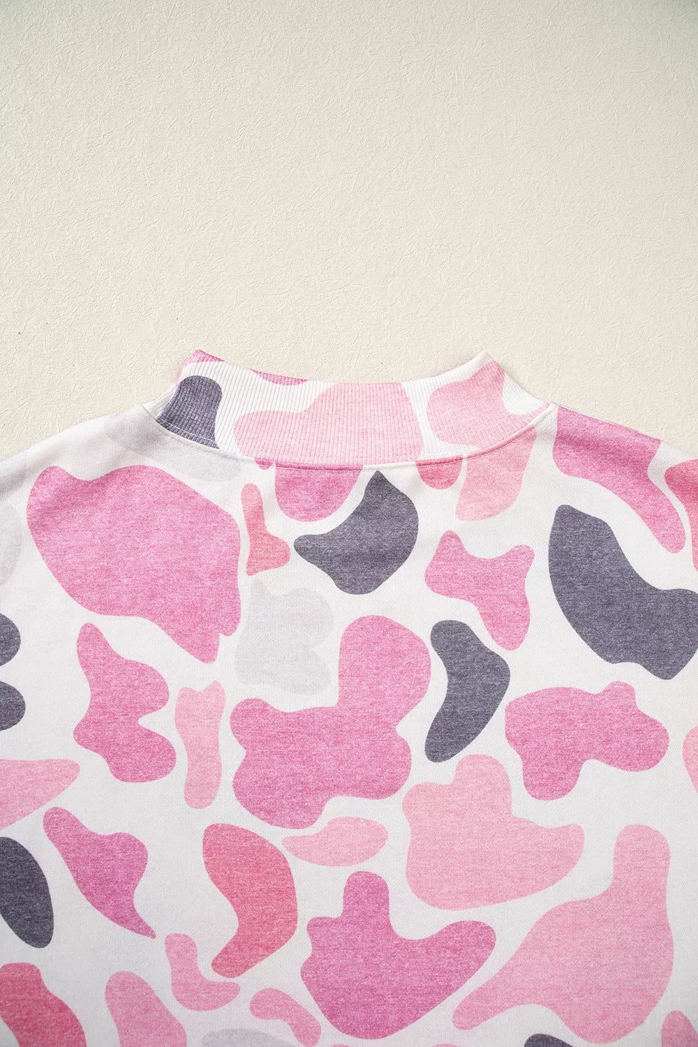 Ribbed mock neck collar detail featuring organic pink grey and white abstract shapes
