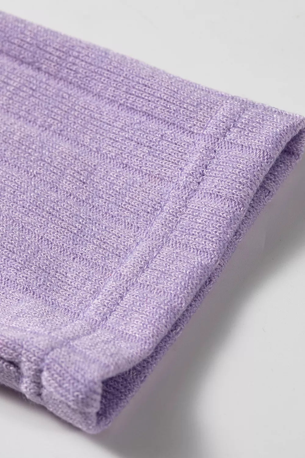 Detail of lavender ribbed sleeve cuff showing elastic finish and polyester elastane blend structure