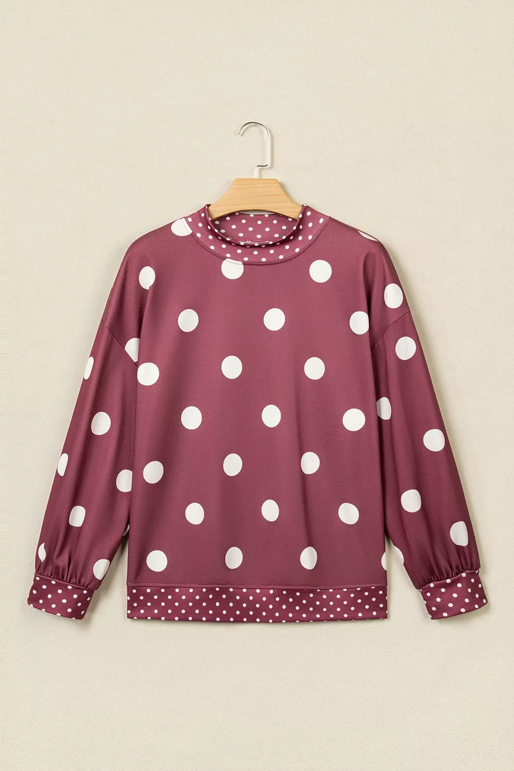 Maroon long sleeve tunic sweatshirt on hanger showing large and small white polka dot patterns