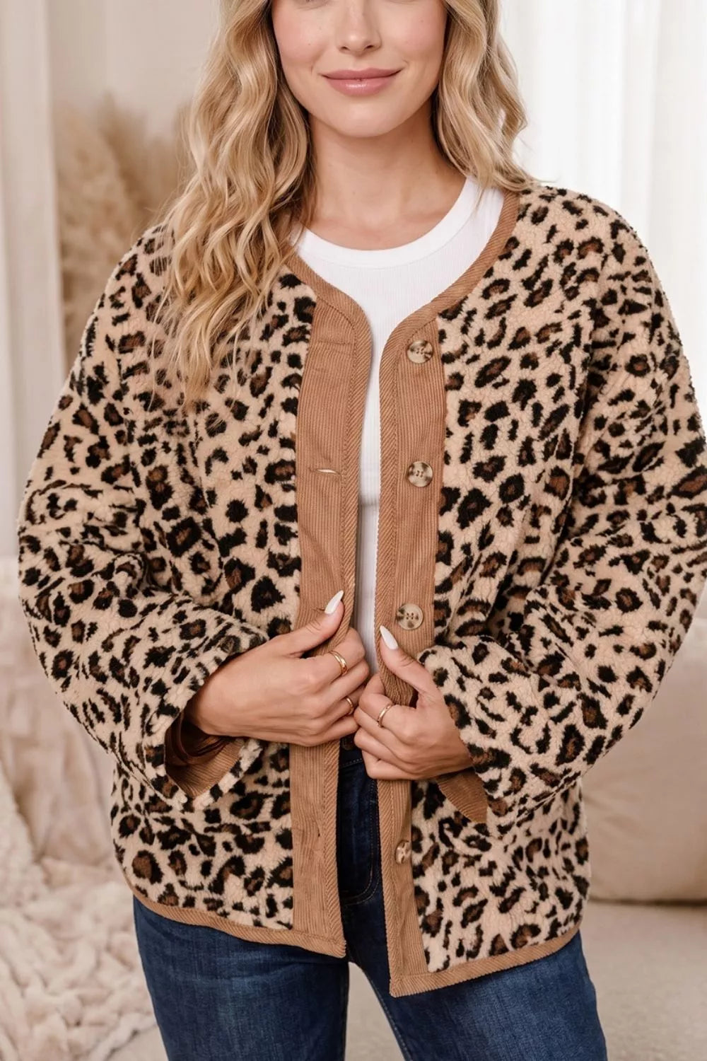 Front view of loose fit leopard print jacket with brown corduroy trim over white tee and denim