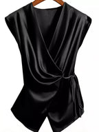 Black draped satin camisole on hanger showing crossover neckline