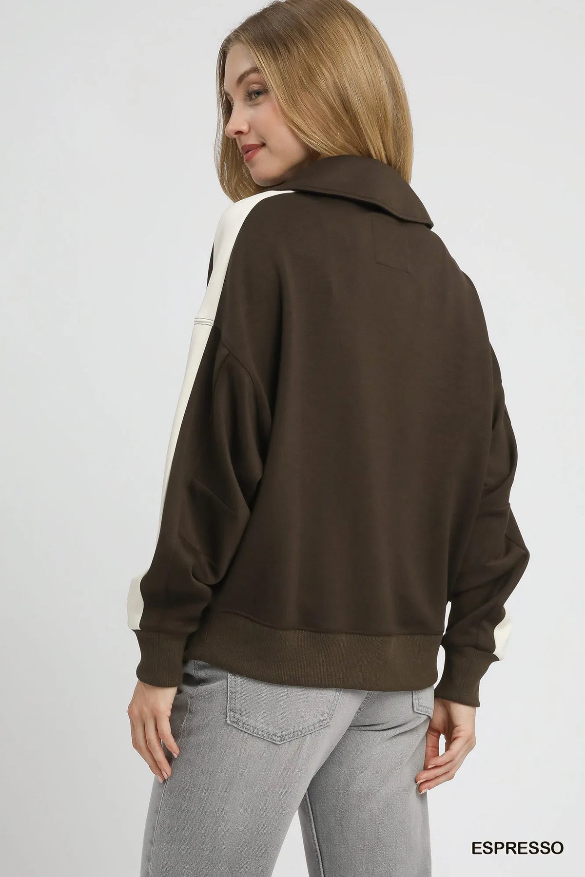 Rear view of plain dark brown back panel contrasting with cream sleeve stripe on polo
