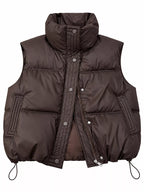 Brown quilted zip-up vest with dual closure and patch pockets on white background