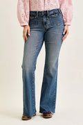 Medium blue Judy Blue flare jeans with front flap pockets and raw hem, worn with a pink blouse