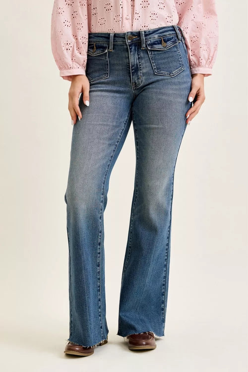 Medium blue Judy Blue flare jeans with front flap pockets and raw hem, worn with a pink blouse