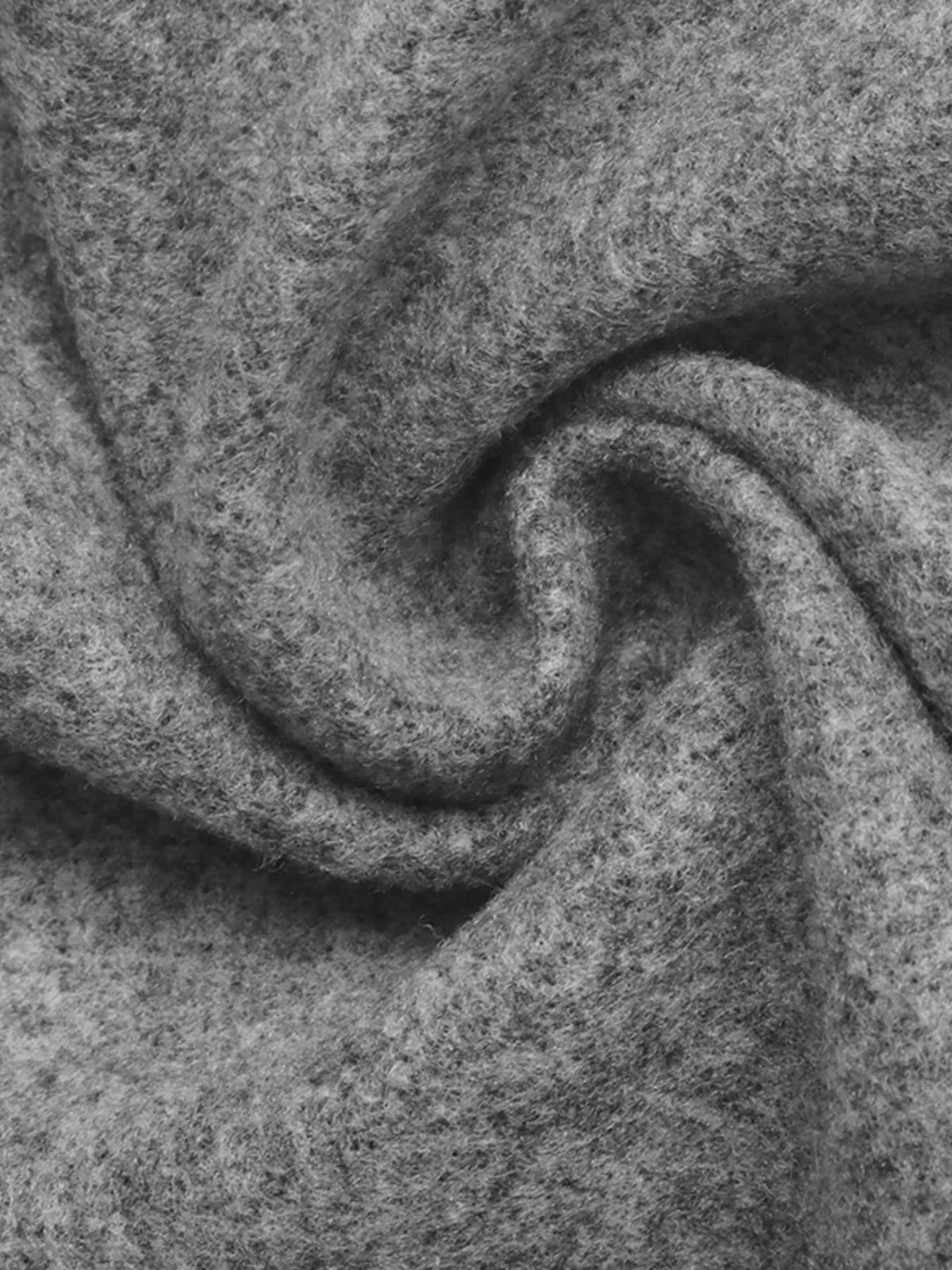Extrem-Nahaufnahme des weichen, flauschigen grauen Materials in schwingenden Falten, die das plüschige Aussehen und matte Finish hervorhebt