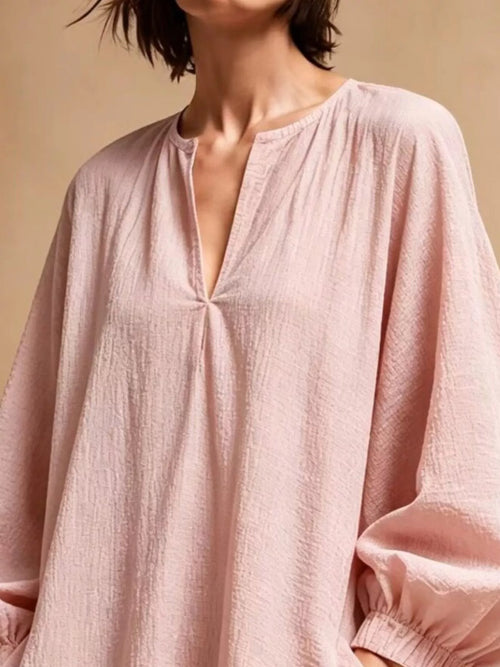 Close-up of dusty pink dress bodice showing crinkled fabric texture and keyhole V-neckline detail