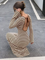 Rückansicht der hockenden Modellin zeigt das offene Rückenausschnitt-Design mit dünnem Bindeverschluss am braunen Kleid