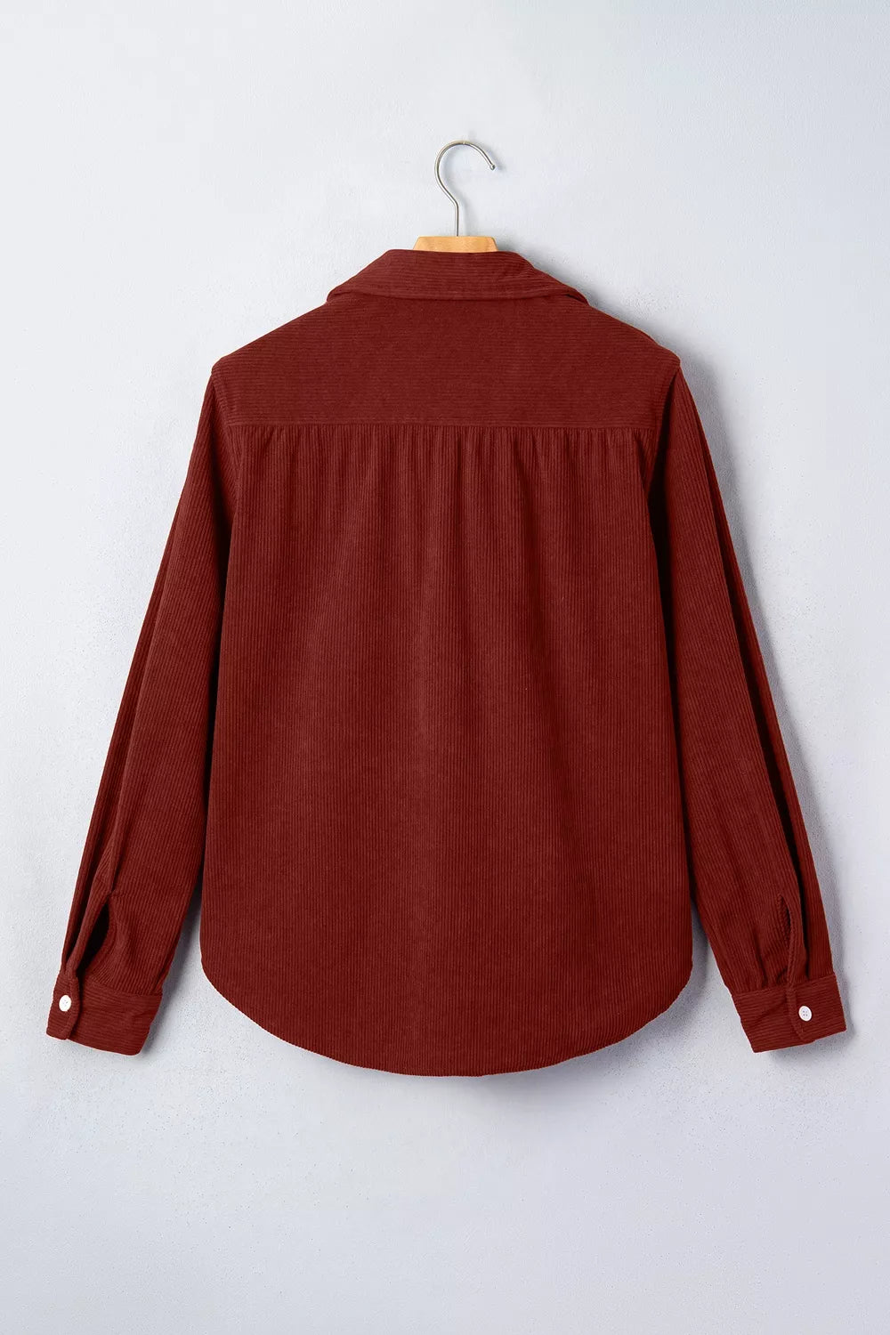 Back view of rust corduroy shirt with horizontal yoke pleats and ribbed texture