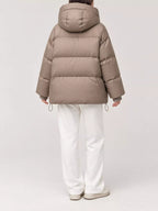 Back view of model in taupe quilted puffer jacket featuring horizontal baffles and adjustable hem drawstrings