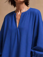 Gros plan buste de la robe bleue roi mettant en valeur l'encolure à boutonnière et le drapé texturé en polyester
