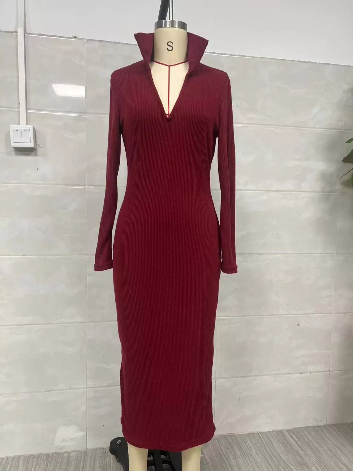 Vue de face d'une robe tricotée côtelée col V bordeaux sur mannequin taille S mettant en avant la silhouette ajustée et le design col V profond