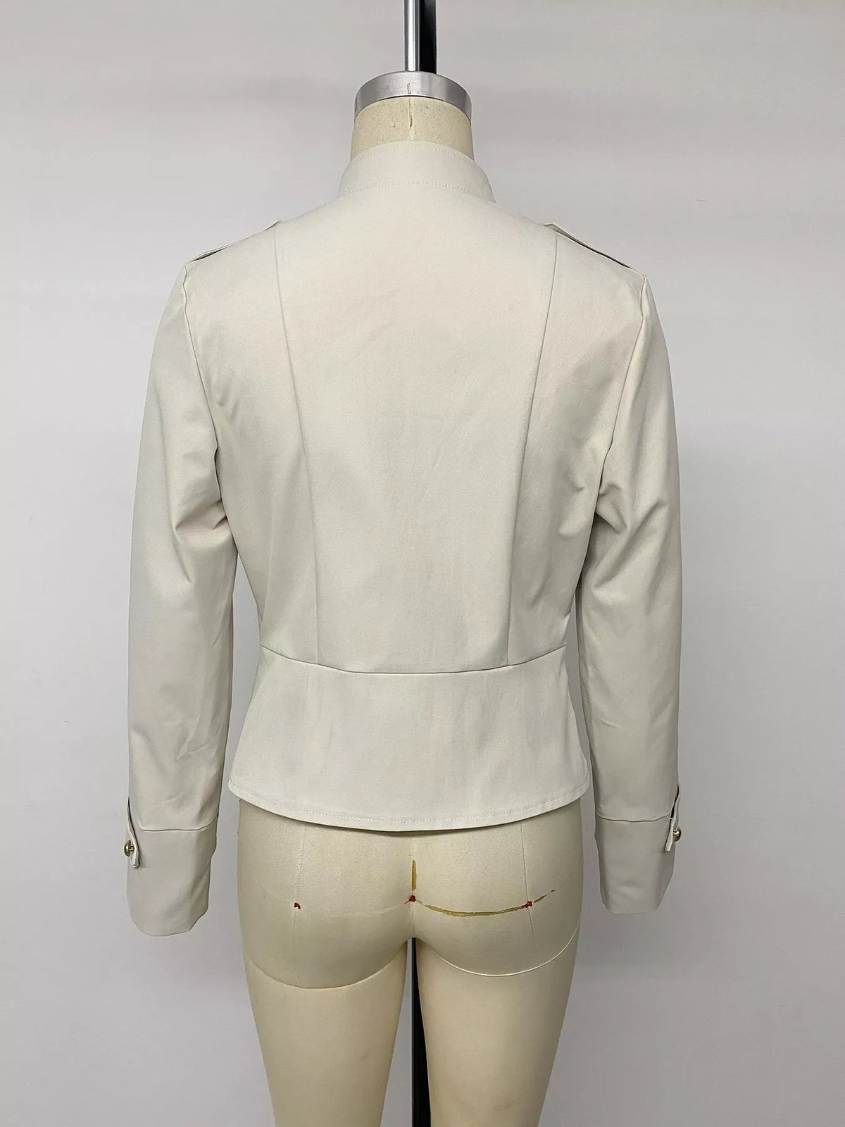 Vue arrière d'une veste crème affichant la couture centrale verticale et la construction des épaulettes