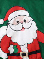 Macro shot of winking cartoon Santa Claus print on green sweatshirt wearing red suit black belt and carrying green sack over