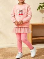 Drei-Viertel-Aufnahme: Mädchen in rosa Baumwoll-Spandex-Leggings mit roten Kirschen