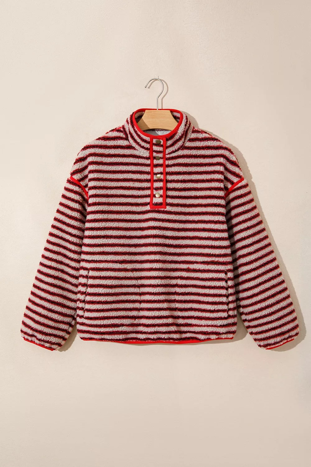 Sudadera fuzzy a rayas en perchero: solapa completa, bolsillos laterales y detalles de ribete rojo
