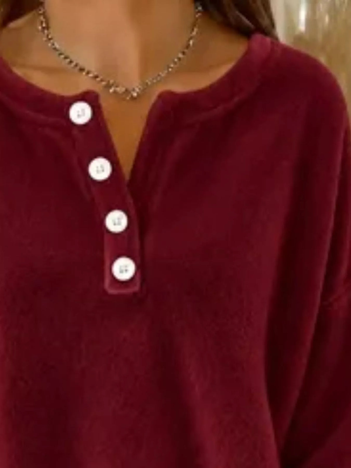Burgundy polyester sweatshirt detail showing fuzzy texture and contrasting white buttons