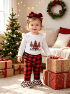 Niña pequeña con camiseta blanca de árbol navideño, pantalones a cuadros rojos y negros con volantes leopardo y diadema a juego