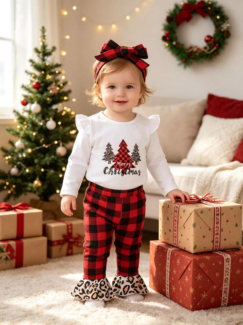 Toddler girl in white Christmas tree graphic top, red black plaid pants with leopard ruffle cuffs, and matching headband