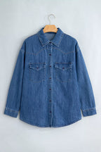 Camisa vaquera azul en percha: cuello puntiagudo, cierre completo, bolsillos parche y yoke vaquero distintivo.