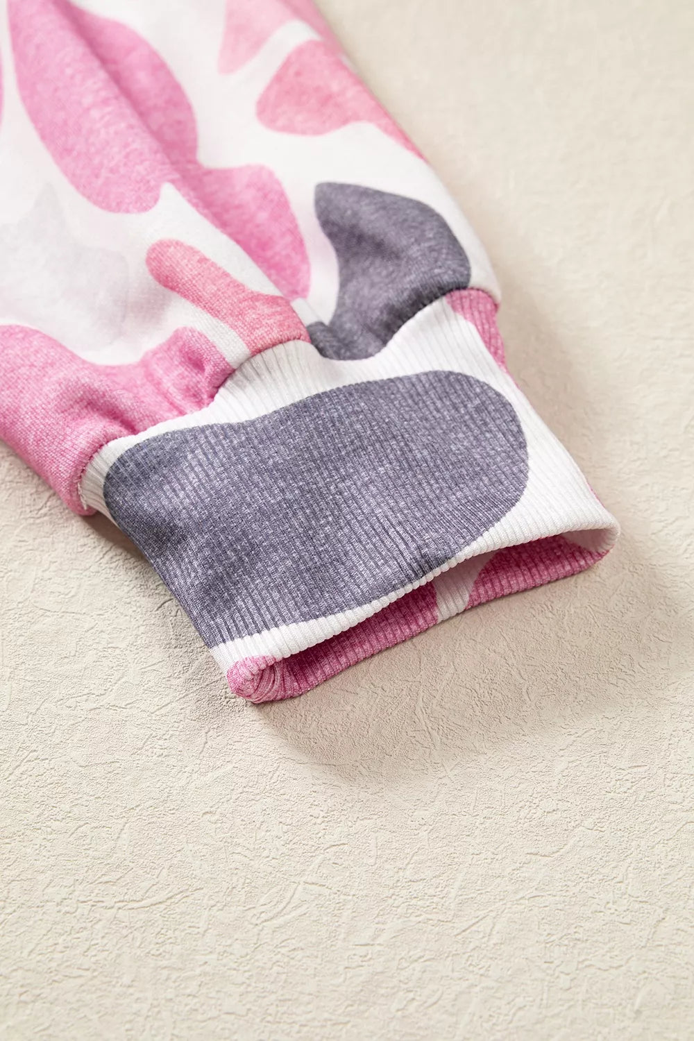 Stretchy ribbed sleeve cuff matching the pink grey camouflage print on fitted wrist design
