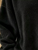 Macro shot of black sweatshirt soft textured fabric and dropped shoulder seam stitching