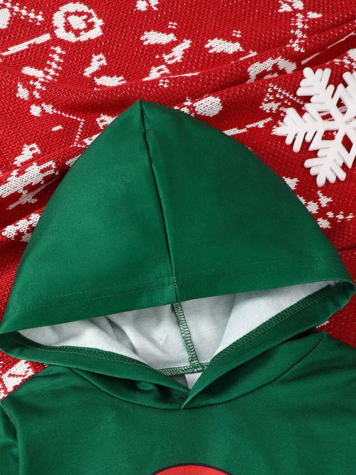 Close up of green hooded sweatshirt hood resting on red snowflake knit fabric showing grey interior lining and seam